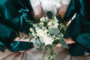Groß (bride her friends hold wedding bouquet) min