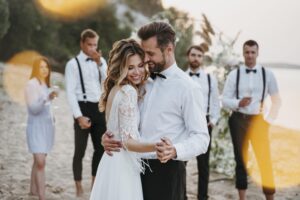 beautiful bride groom having their wedding with guests beach min